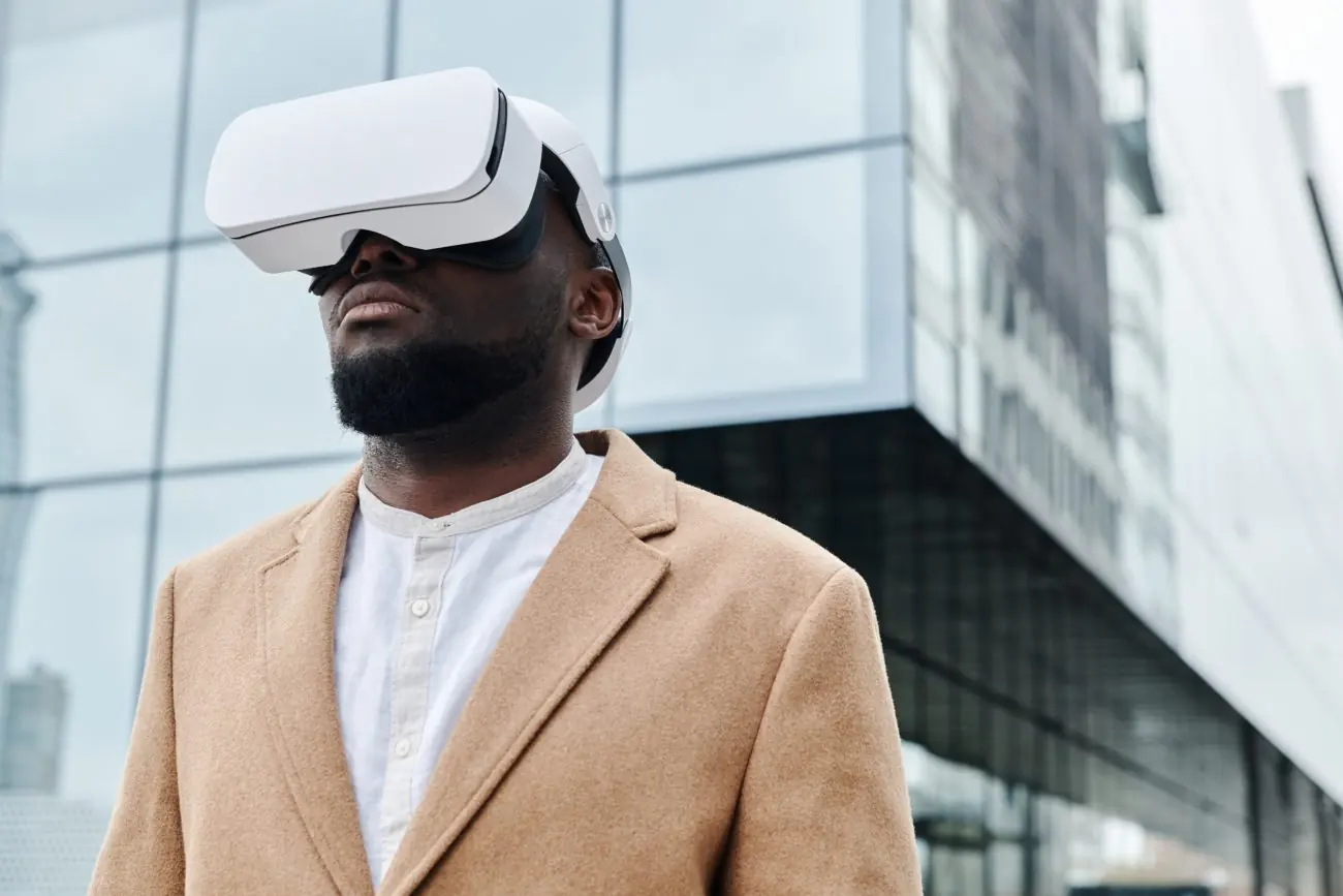 Man in a business suit wearing a virtual reality headset in front of an office building